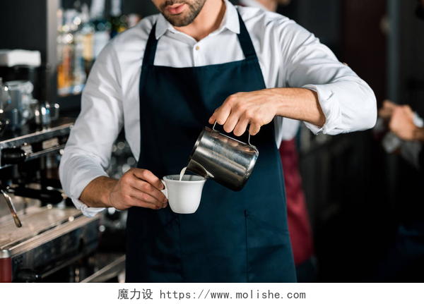 咖啡厅制作咖啡的男人裁剪视图咖啡师在围裙倒牛奶咖啡在工作场所